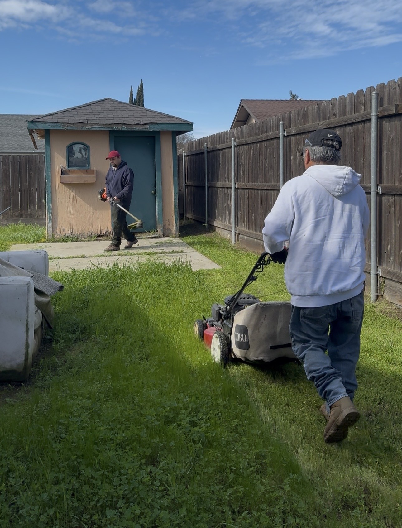 VerdePath crew mowing and trimming backyard